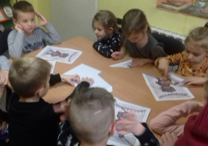 Dzieci układają puzzle z misiem